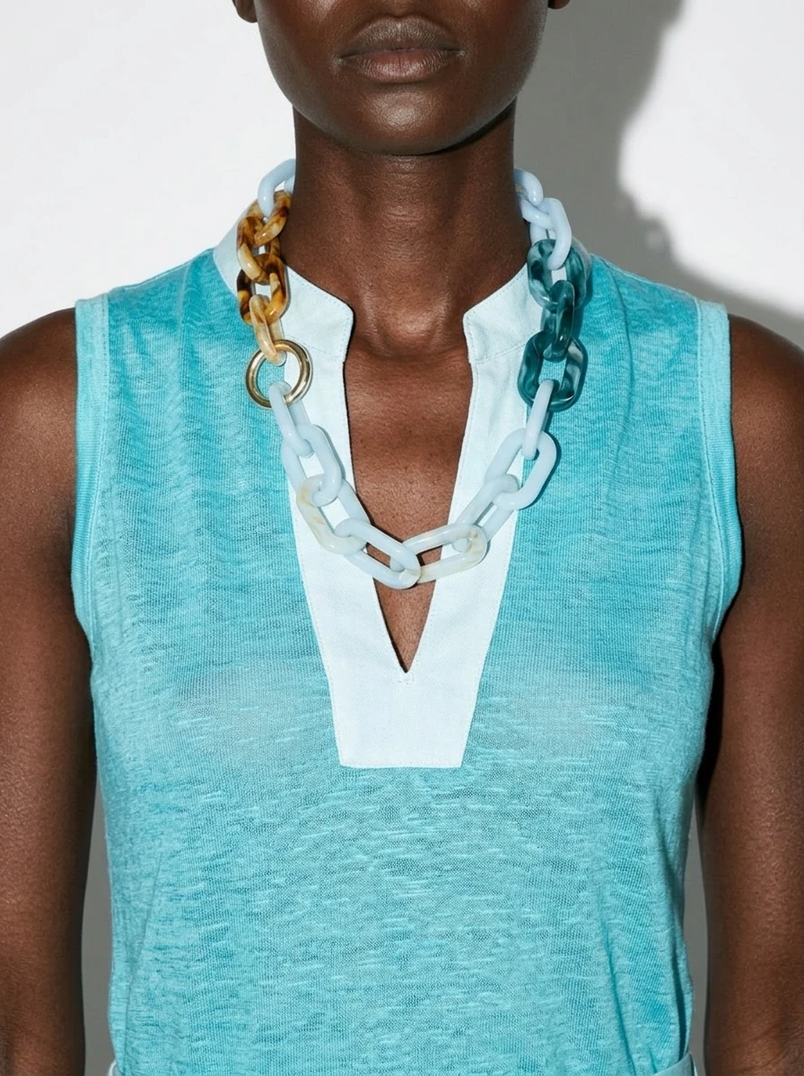 Collana a maglie colorate su un abito turchese.